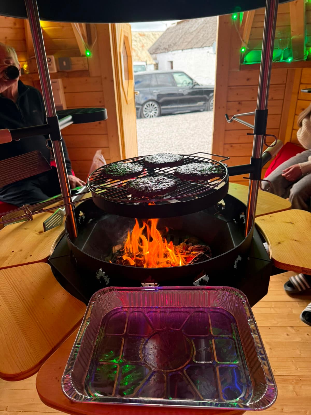 Burgers cooking on the BBQ hut's charcoal grill