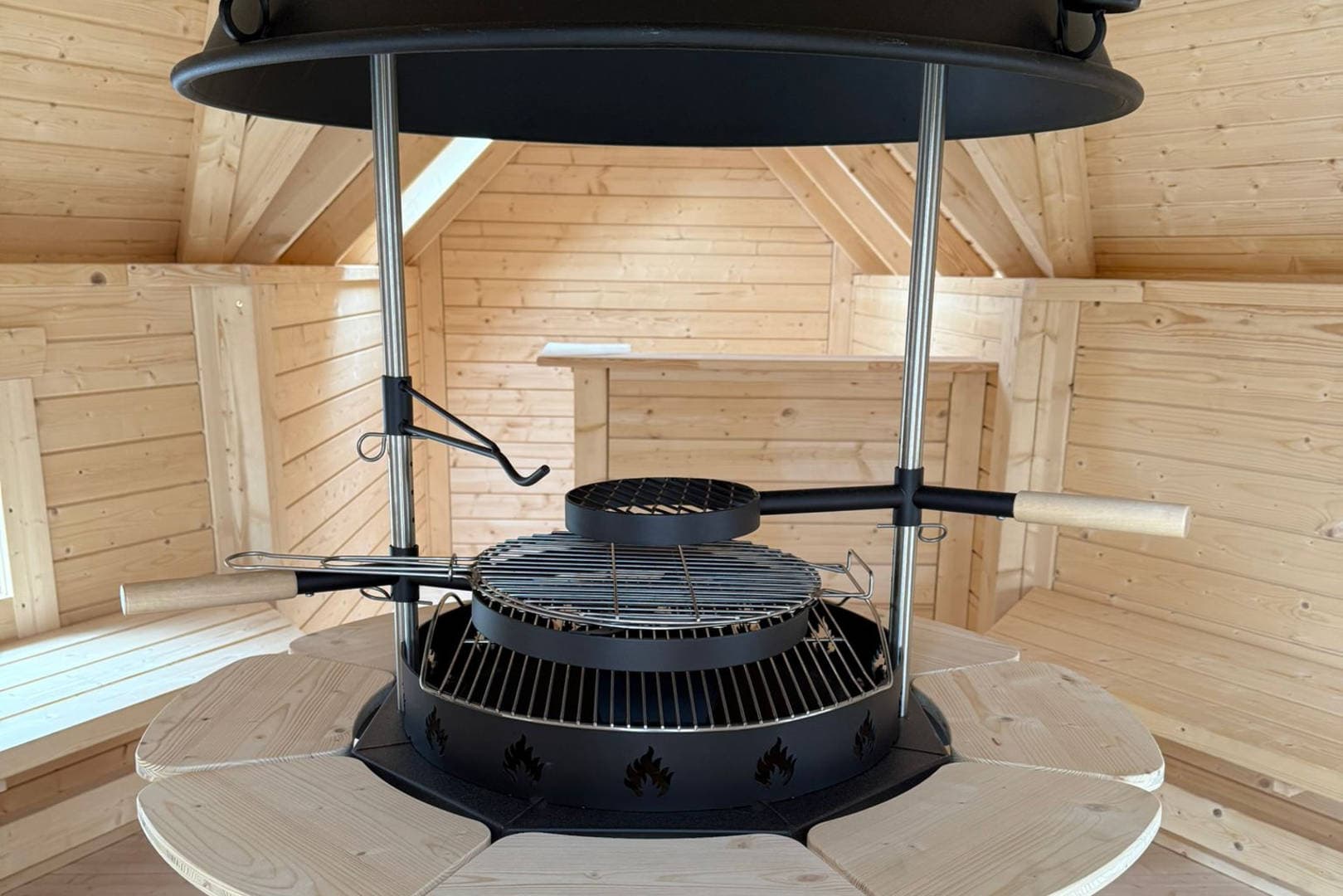 The central charcoal grill inside the Scandinavian-style BBQ hut