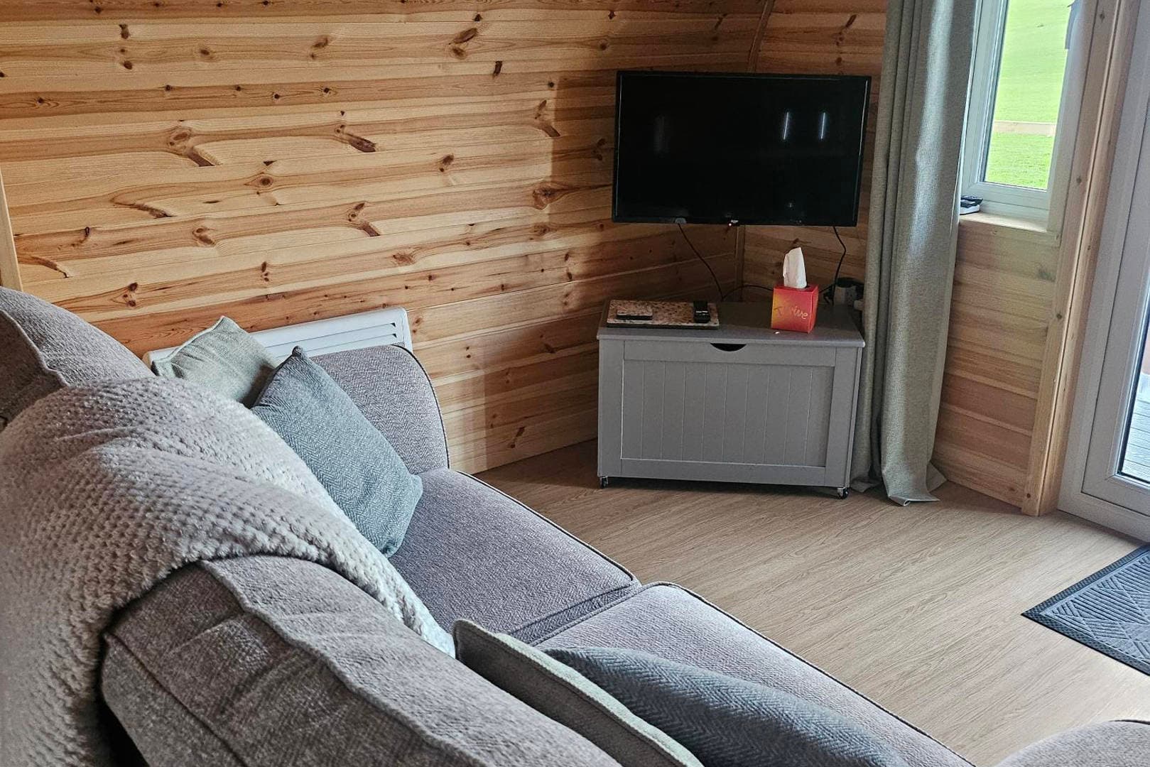 The sofa and wall-mounted TV inside a pod