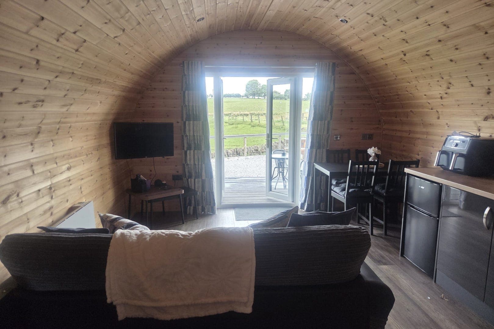 Inside a pod: the kitchen, dining table, sofa and TV corner
