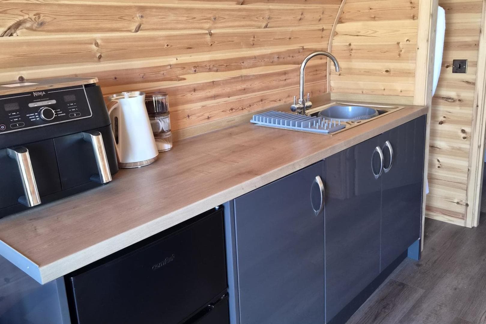 The kitchenette counter with air fryer, kettle and sink