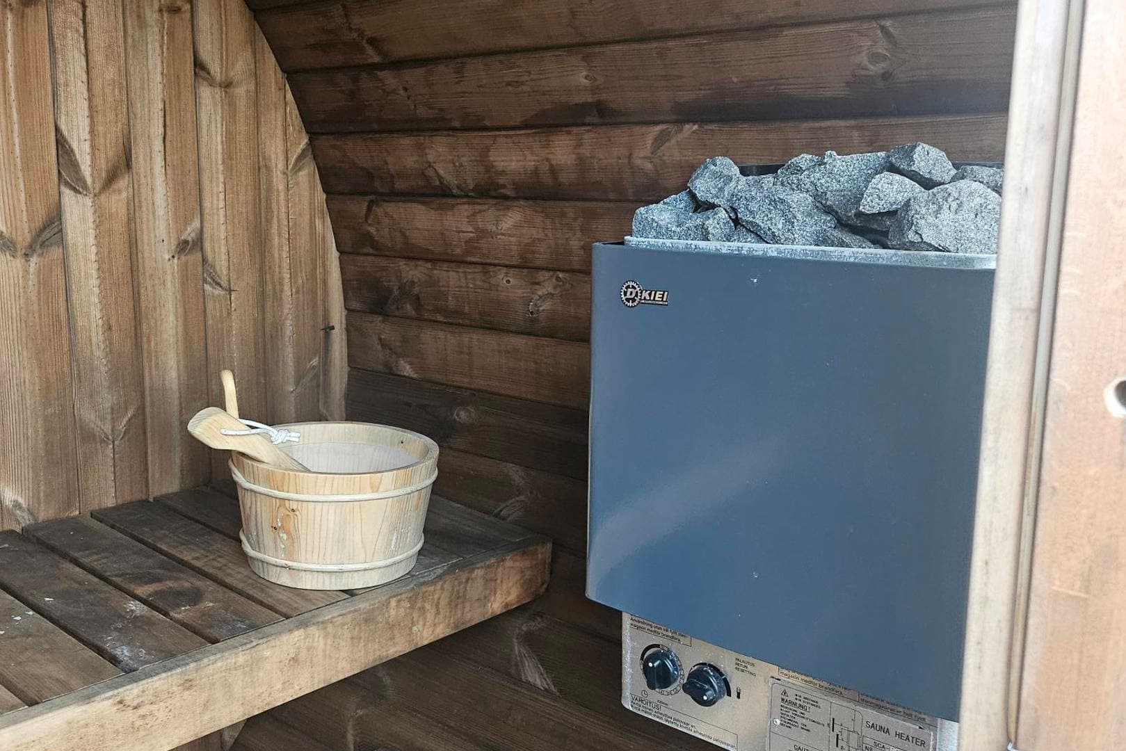 Inside the barrel sauna: the wood-fired heater and stones