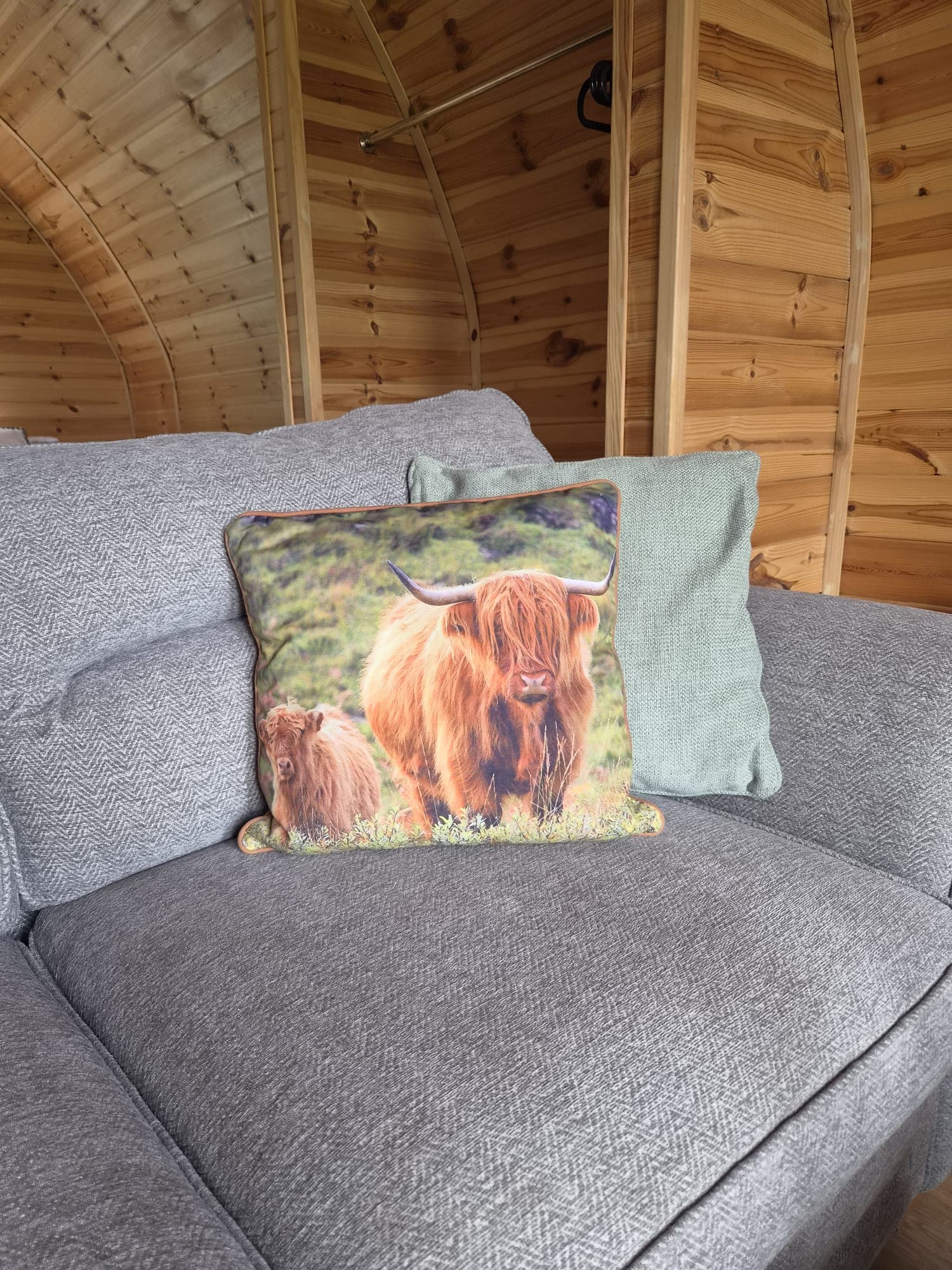 A Highland cow cushion on the Thistle Pod sofa