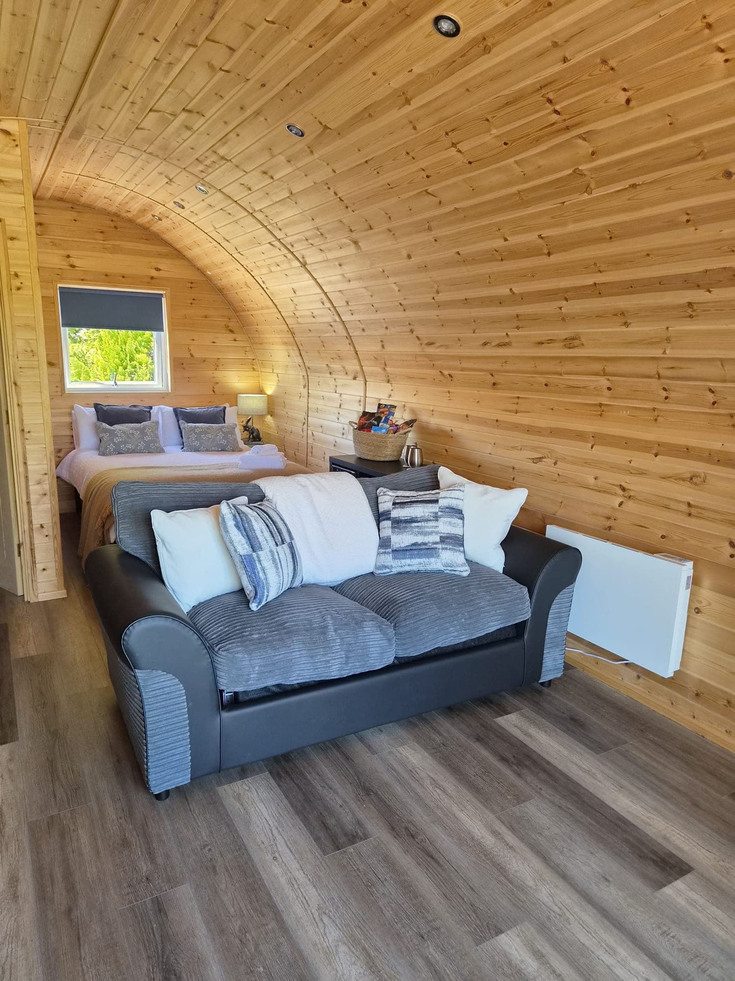 The Thistle Pod's sofa bed, with the double bed beyond