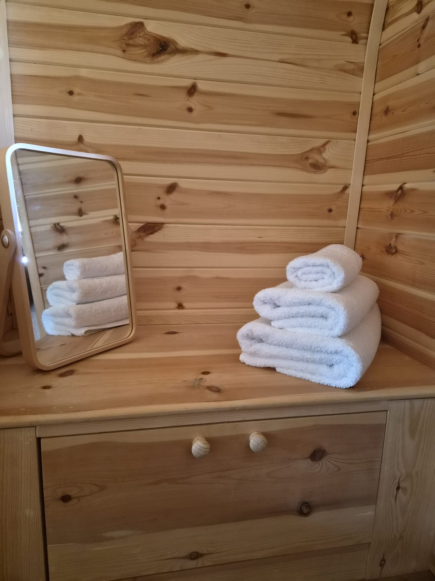 Folded towels and a mirror in the Thistle Pod