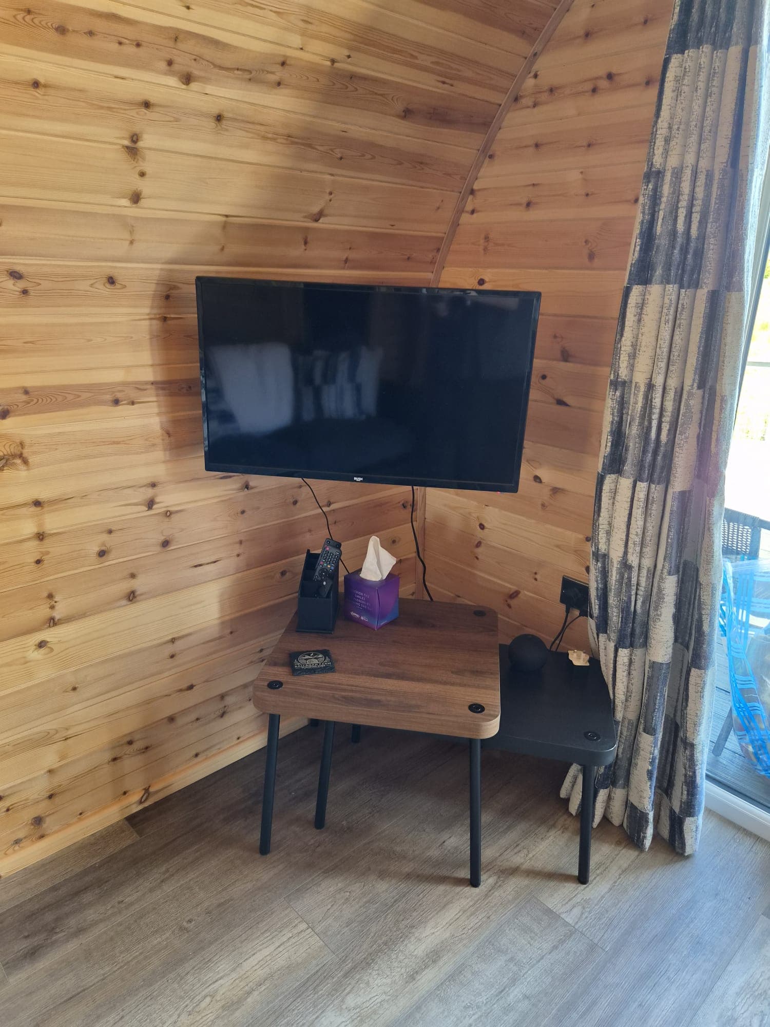 The wall-mounted TV and side table in the Thistle Pod